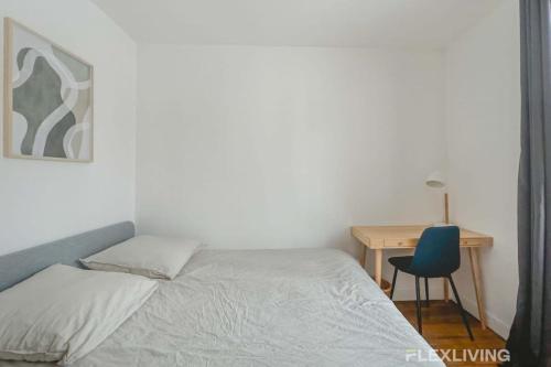 - une chambre avec un lit et un bureau avec une chaise bleue dans l'établissement Flexliving - room - Saint Martin, à Paris