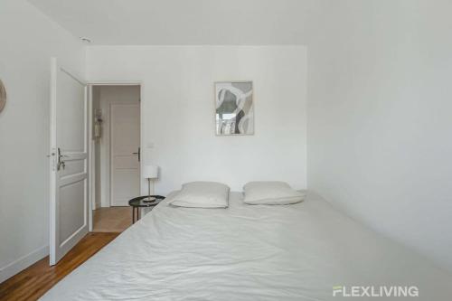 - une chambre blanche avec un grand lit blanc dans l'établissement Flexliving - room - Saint Martin, à Paris