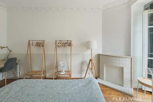 - une chambre avec des murs blancs, un lit et une table dans l'établissement Flexliving - room - Prague, à Paris