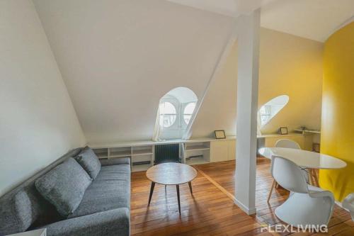 un salon avec un canapé et une table dans l'établissement Flexliving - Onebedroom - Malesherbes - Eiffel Tower view, à Paris