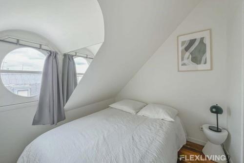 une chambre blanche avec un lit et une fenêtre dans l'établissement Flexliving - Onebedroom - Malesherbes - Eiffel Tower view, à Paris