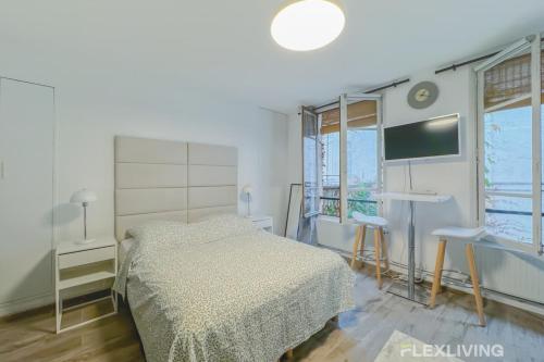 une chambre avec un lit et une télévision à écran plat dans l'établissement Flexliving - Studio - Jarente, à Paris