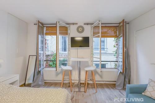 - un salon avec une table et deux tabourets dans l'établissement Flexliving - Studio - Jarente, à Paris