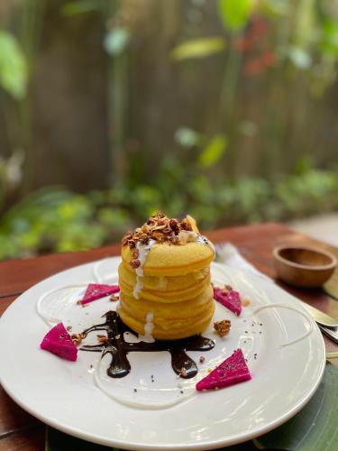 een stapel pannenkoeken op een bord op een tafel bij Penida West palm cottage in Nusa Penida