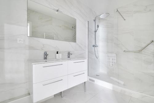 une salle de bain blanche avec un lavabo et une douche dans l'établissement Pick A Flat's apartment in Avenue Foch - Rue Leroux, à Paris