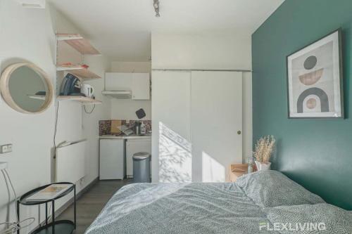 une petite chambre avec un lit et une cuisine dans l'établissement Flexliving - Studio - Longchamps, à Paris