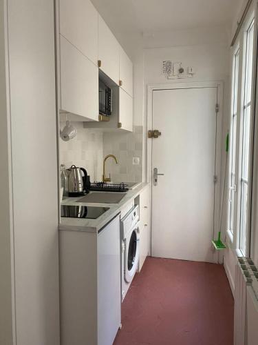 une cuisine blanche avec un lave-linge et un lave-linge dans l'établissement Flexliving - Studio - Paradis, à Paris