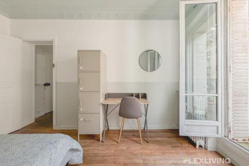 a bedroom with a desk and a chair next to a window at Flexliving - room - Paris 15 in Paris