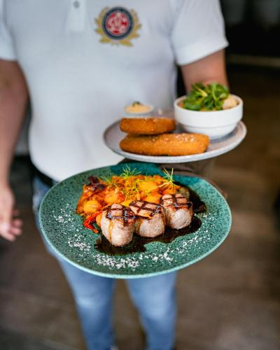 a person holding a plate of food on a plate at Avalon Resort & SPA in Miskolctapolca