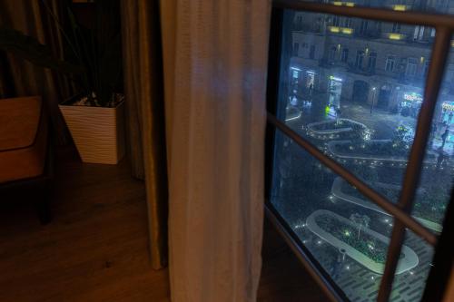 a view of a city at night from a window at Square Boutique Hotel in Baku
