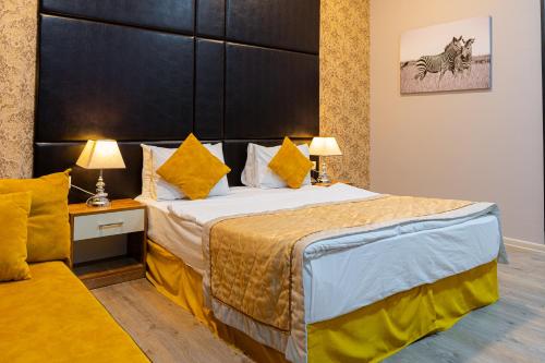 a bedroom with a large bed with a large headboard at Square Boutique Hotel in Baku