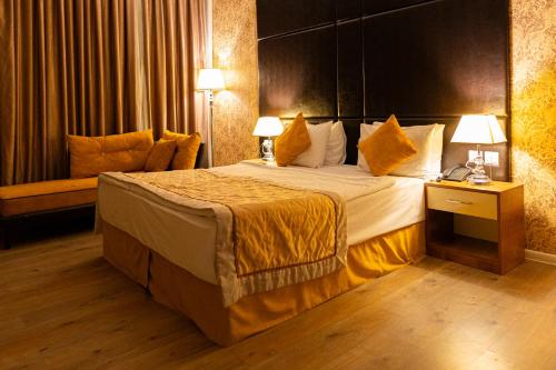 a hotel room with a large bed and a couch at Square Boutique Hotel in Baku