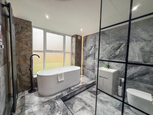 a bathroom with a bath tub and a toilet at Santi House in Boston