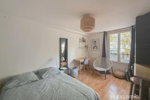 une chambre avec un lit, un bureau et une fenêtre dans l'établissement Flexliving - Studio - St Antoine, à Paris