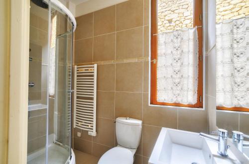 a bathroom with a toilet and a sink and a shower at Maison au coeur de Sarlat pour 4 personnes in Sarlat-la-Canéda
