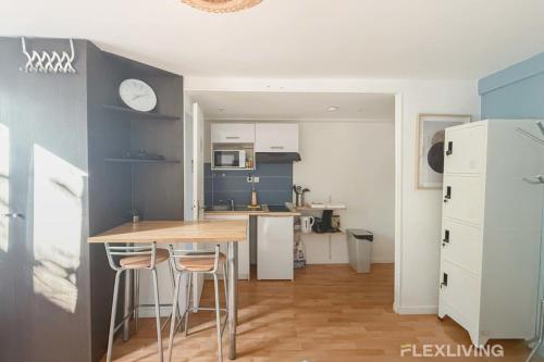 une cuisine avec une table et des chaises dans une pièce dans l'établissement Flexliving - Studio - St Antoine, à Paris