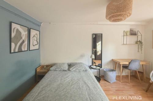 une chambre avec un lit, une table et un bureau dans l'établissement Flexliving - Studio - St Antoine, à Paris