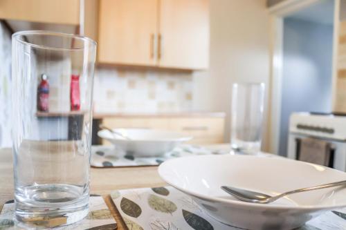 une table avec un bol et un verre sur une table dans l'établissement 3 BDR Entire Home Sleeps Up to 5 Contractors & Families Long or Short Stay Free WiFi & Parking, à Lynemouth
