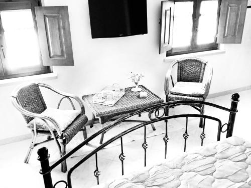 a bed with two chairs and a table in a room at Prestige Room- Salotto Interno- Frigobar- Esperienze Esclusive nel Territorio - Tutti i confort in Làconi
