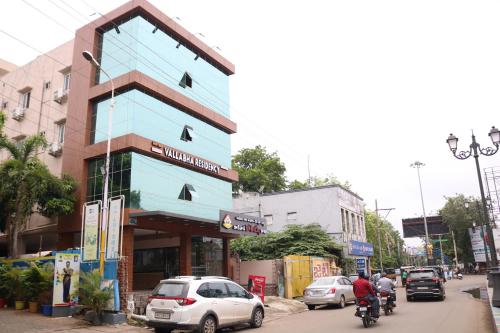 a blue building on a busy city street with cars at HOTEL VALLABHA RESiDENCY in Rājahmundry