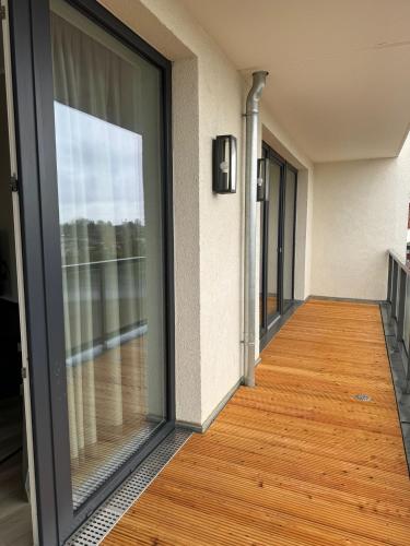 an empty hallway with glass doors and a wooden floor at Exklusives Wohnen im historischen Wasserturm dem Highlight von Delitzsch WE210 in Delitzsch