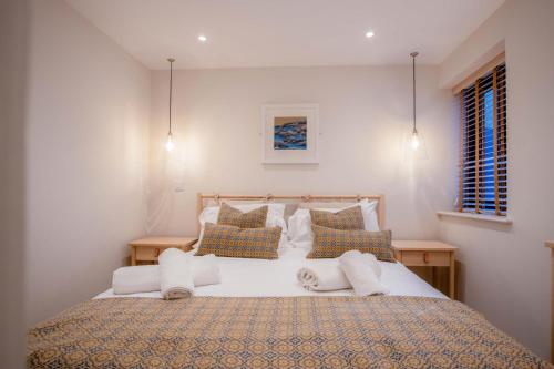 Ty Florence - 3 Bedroom Cottage - Bayview Oxwich في أوكسويتش: غرفة نوم بها سرير كبير مع وسائد