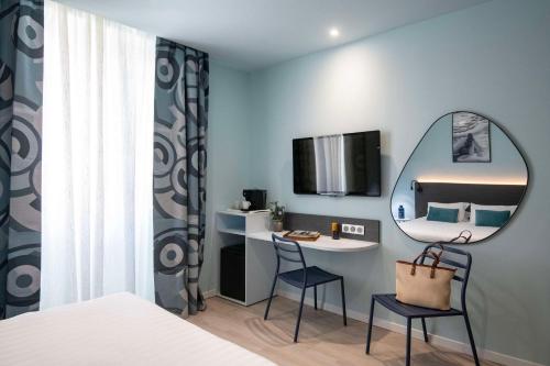 une chambre avec un lit, un miroir et un bureau dans l'établissement Best Western Alba, à Nice