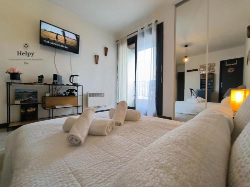 une chambre avec un grand lit avec des serviettes dessus dans l'établissement Joli Studio lumineux Centre ville Parking gratuit, à Pau