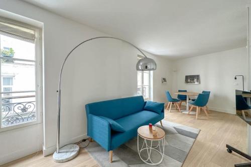 un salon avec un canapé bleu et une table dans l'établissement Flexliving - Whole Flat - Beauregard, à Paris