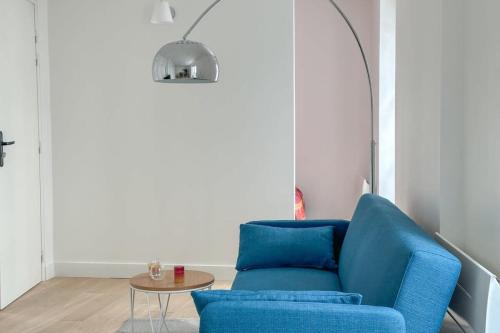 une chaise bleue dans un salon avec une table dans l'établissement Flexliving - Whole Flat - Beauregard, à Paris