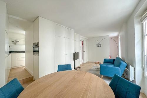 un salon avec une table et des chaises bleues dans l'établissement Flexliving - Whole Flat - Beauregard, à Paris
