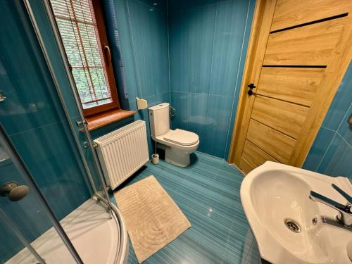 Un baño azul con inodoro y lavabo. en Zinc FAM, en Oświęcim