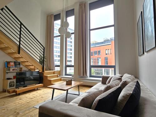 a living room with a couch and a television at spacious modern LOFT, 2 bedrooms, 95m2, free parking in Bratislava