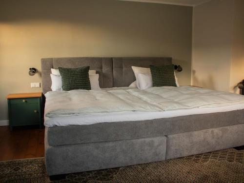 a large bed in a bedroom with a gray headboard at Ferienhaus Hallmanns Hof in Schmallenberg