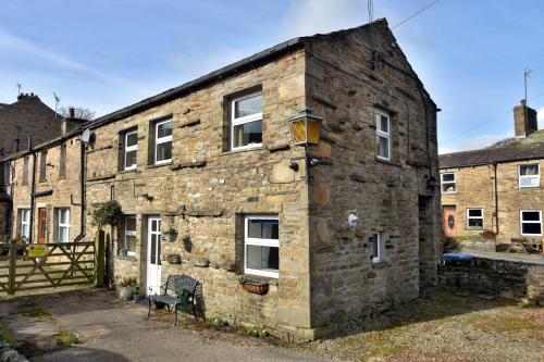 an old stone building with a fence in front of it at Finest Retreats - Dales Barn Top in Hawes