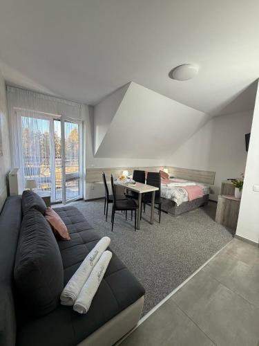 a living room with a couch and a bedroom at Natalii in Kudowa-Zdrój