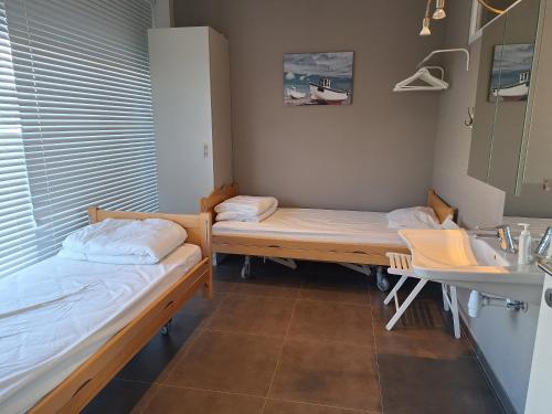 sala szpitalna z dwoma łóżkami i umywalką w obiekcie Equus w Ostendzie