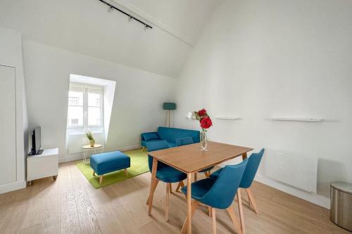 une salle à manger avec une table et des chaises bleues dans l'établissement Flexliving - appartement - Beauregard, à Paris