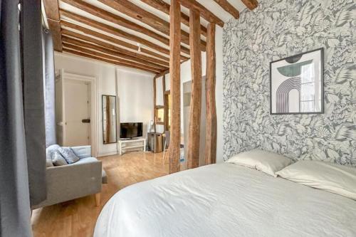 une chambre avec un lit, un canapé et une télévision dans l'établissement Flexliving - Studio - Linné, à Paris