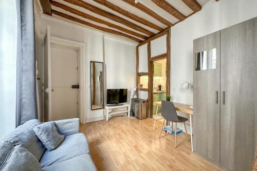 un salon avec un canapé bleu et une table dans l'établissement Flexliving - Studio - Linné, à Paris