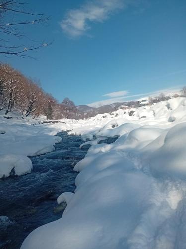 a river covered in snow next to a river at Istisu Valley Spa in İsmayıllı