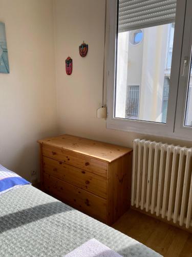 - une chambre avec une commode en bois et une fenêtre dans l'établissement Chambre chez l'HABITANT appartement partagé sauf salon, à Angers