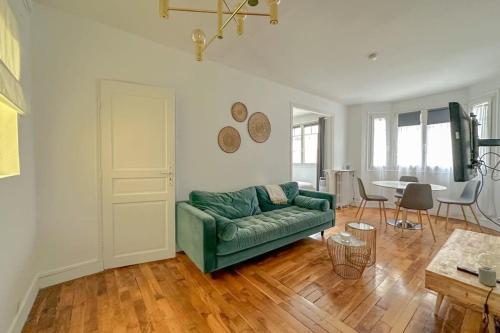 un salon avec un canapé vert et une table dans l'établissement Flexliving - T2 - Médéric, à Paris