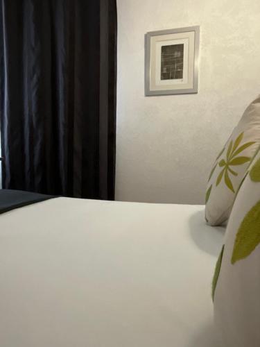 - un lit blanc avec un oreiller et une fenêtre dans l'établissement HOTEL De La Tour Saint Etienne SUD, à Saint Etienne