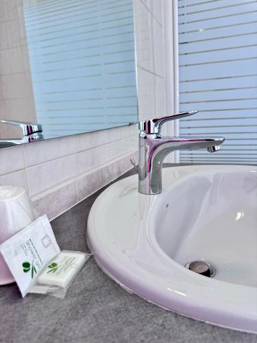 un lavabo de salle de bain avec un robinet et un miroir dans l'établissement HOTEL De La Tour Saint Etienne SUD, à Saint Etienne