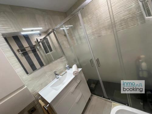 un baño con lavabo y espejo en Paradis Sant Sebastian , climatizado y con piscina, en Salou