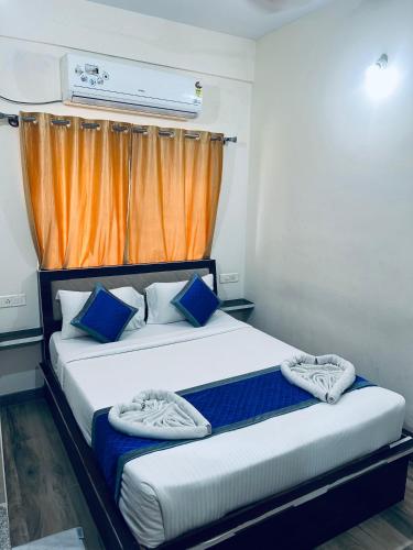 a bedroom with two beds and an orange curtain at SM Rooms HSR Layout Bengaluru in Bangalore