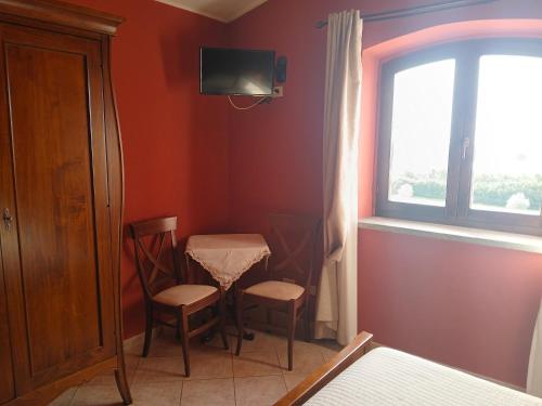 a room with a table and two chairs and a window at Villa Klinai in Cerveteri