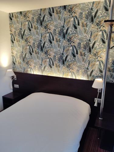 a bedroom with a bed with a wallpaper with birds on it at Hôtel Inn Design Resto Novo Langres in Langres