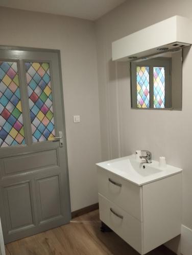 a bathroom with a sink and a stained glass door at La grange du Lucimond in Saint-André